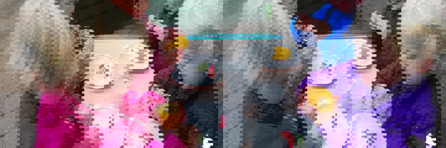 Fire børn i alderen 1 til 2 år spiser majs.