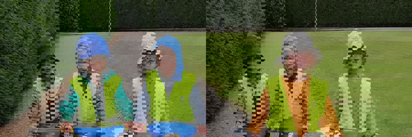 Tre børn mellem et og to år sidder på små scootere.