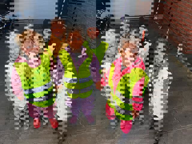 Fem børn i alderen 1 til 2 år har overtøj og gule veste på.